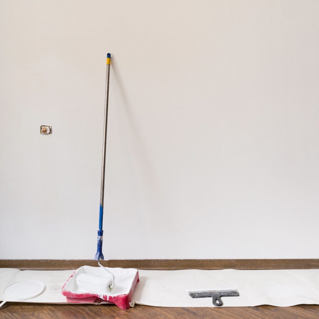 Painting white wall at home. Painting tools and materials