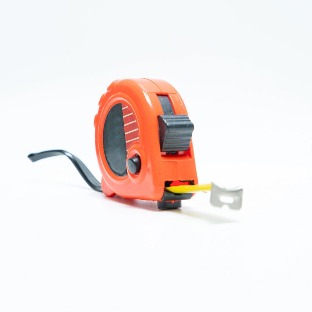 Orange retractable measuring tape isolated on white background